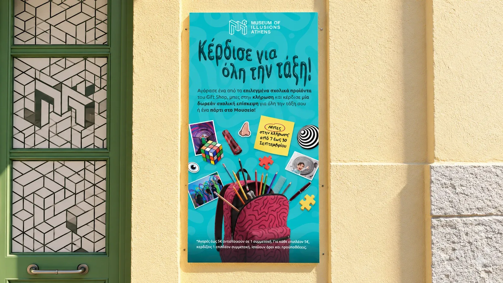 A foam board poster on a yellow Athens wall announcing a gift shop giveaway: buy school supplies and win a free class visit to the museum