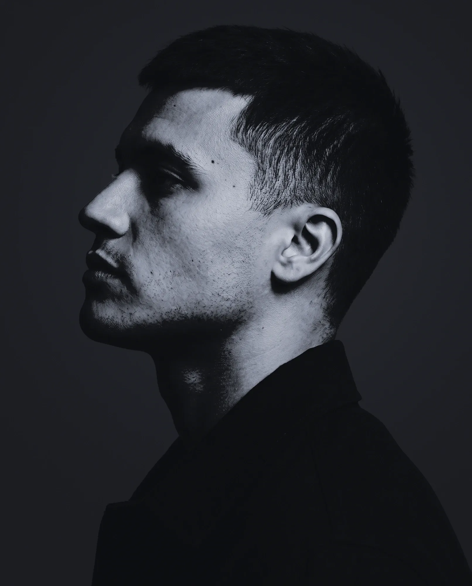 Iraklis in profile, in a dark jacket, looking left.
